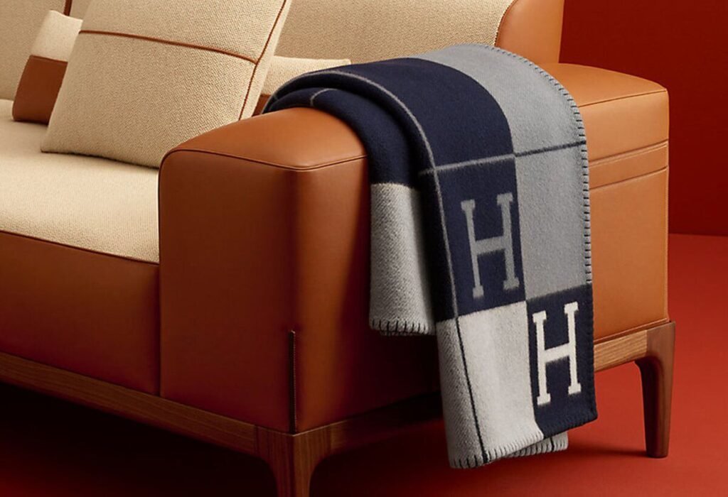 Luxury wool throw draped over a leather sofa — designer blanket cleaning Sydney