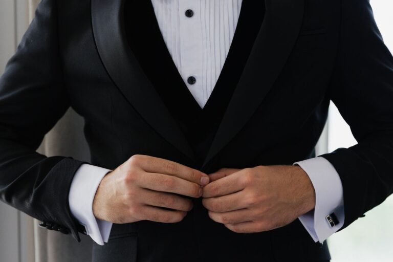 Black shawl-collar tuxedo being buttoned — tuxedo dry cleaning Sydney